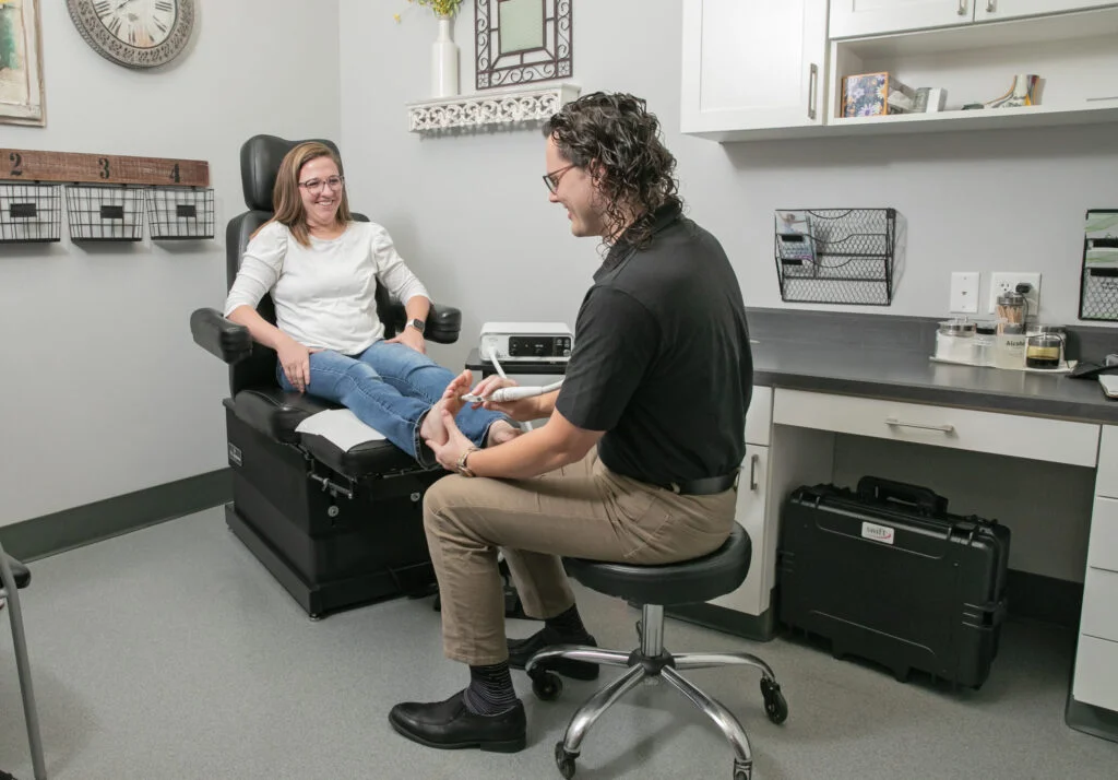 Healthcare professional examining a patient's foot during a consultation.