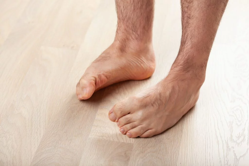 Person standing with both feet tilted outward.