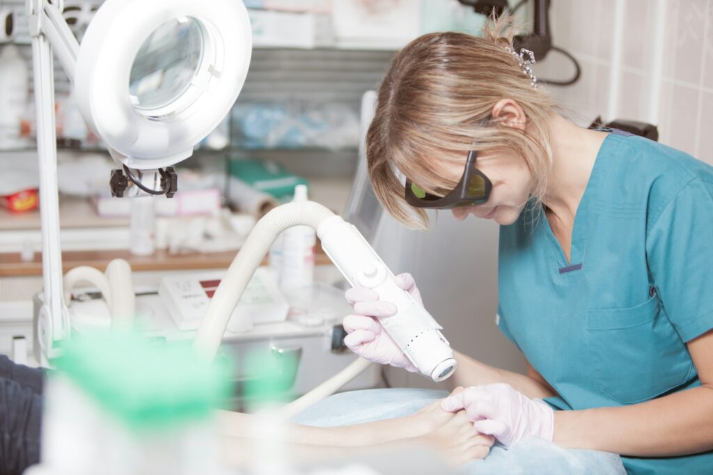 Healthcare professional performing treatment on a patient's foot.