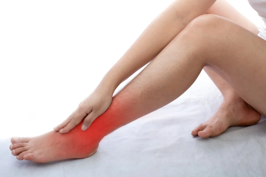 Person holding their ankle in pain