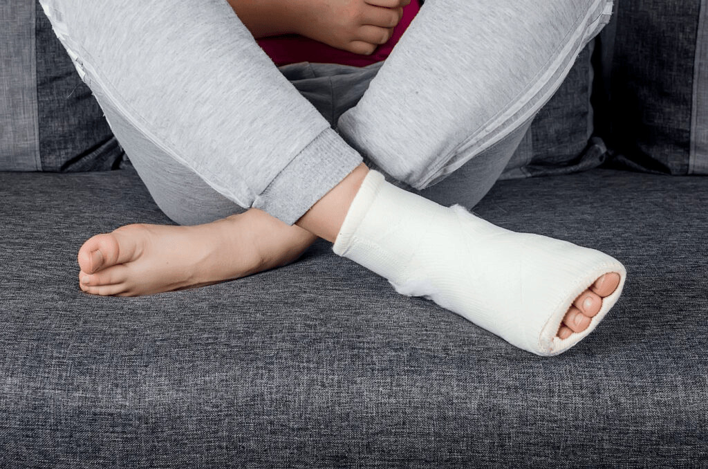 Person with a bandaged foot resting on a couch, representing wound care, ulcers, and limb preservation.